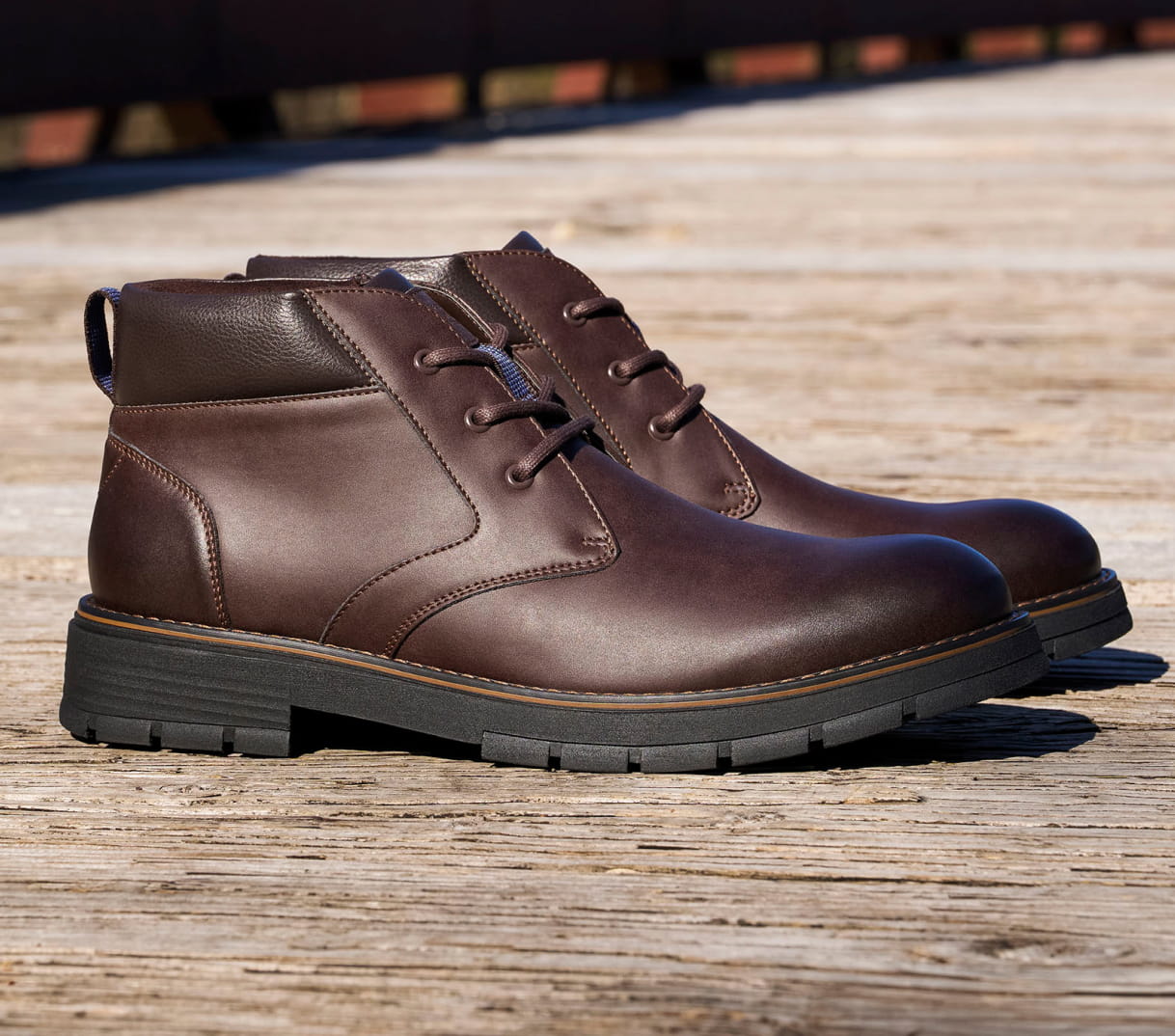 Shop Nunn Bush boots featuring the Briggs Chukka boot in chocolate brown on a wood surface.