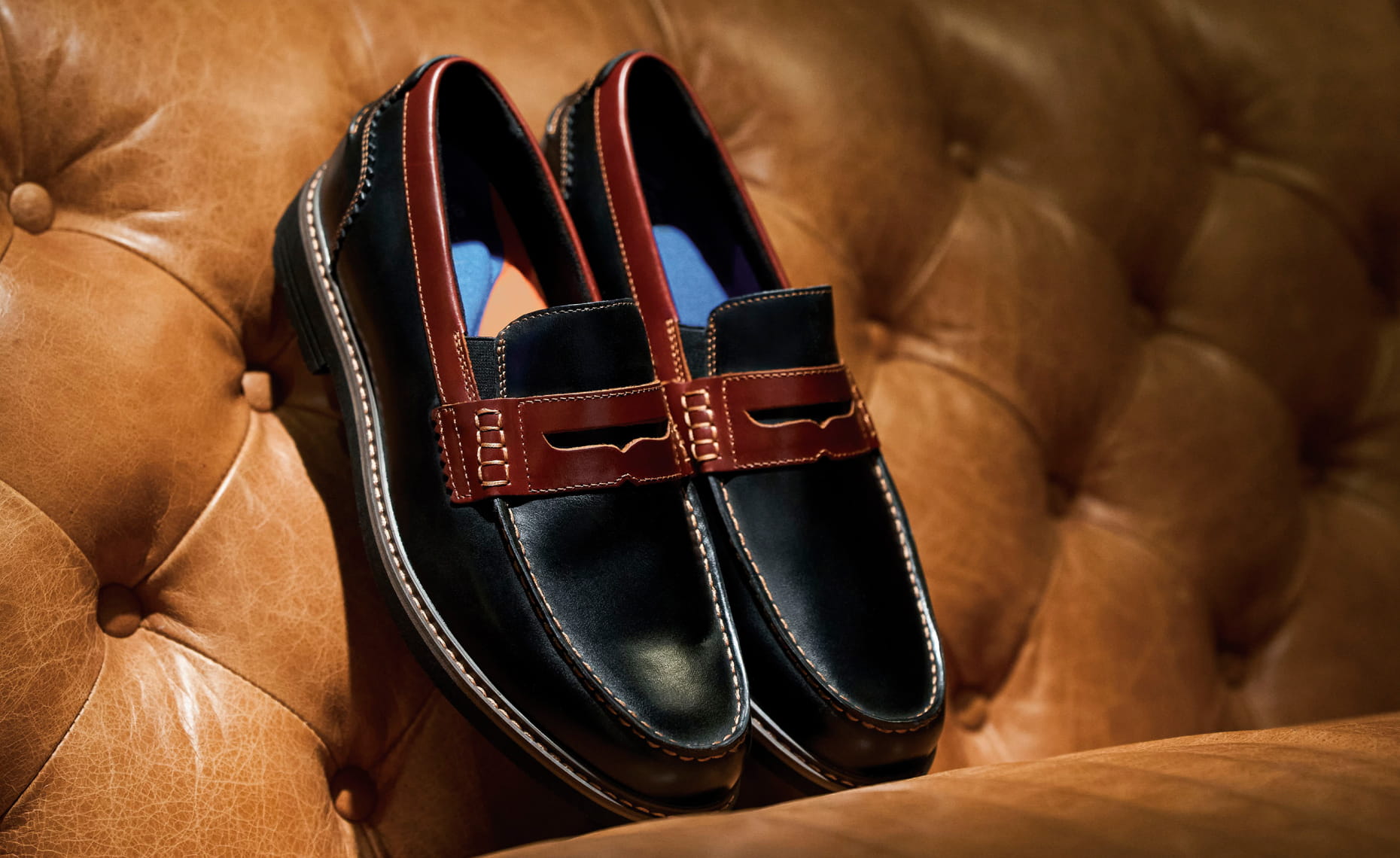 Shop Nunn Bush dress featuring the Odin Moc Toe Penny in black on a cognac leather sofa. 