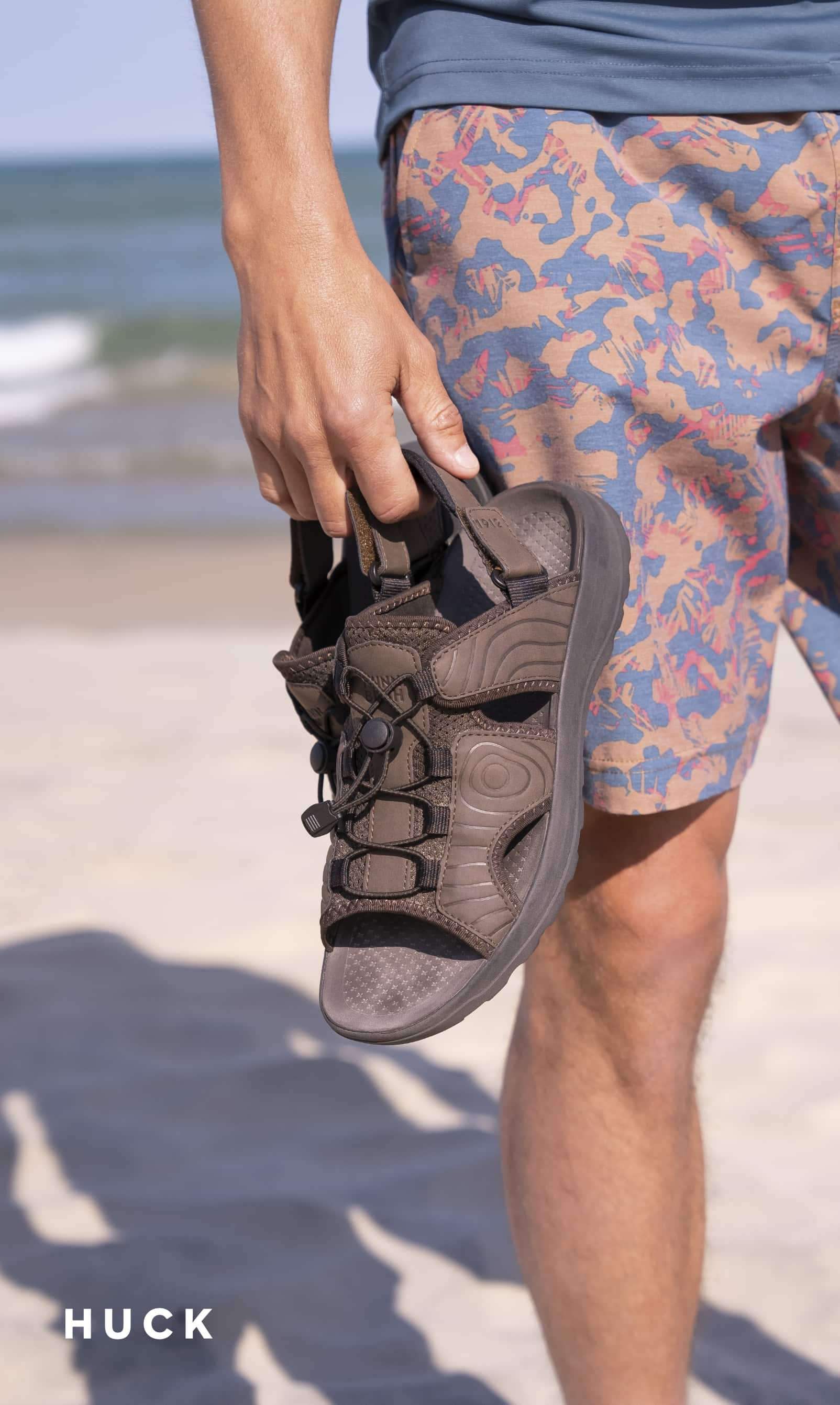 Men's Sandals category. Image features the Huck Bungee sandal in brown.
