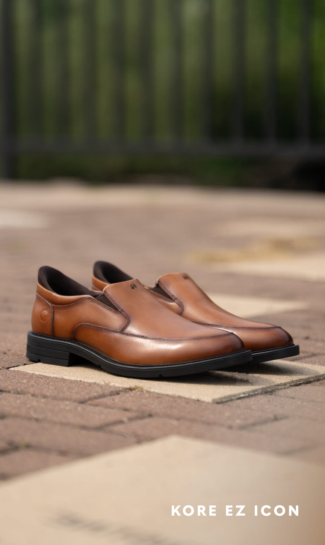KORE EZ Icon Image features the KORE EZ Icon Slip On in cognac on a brick background.